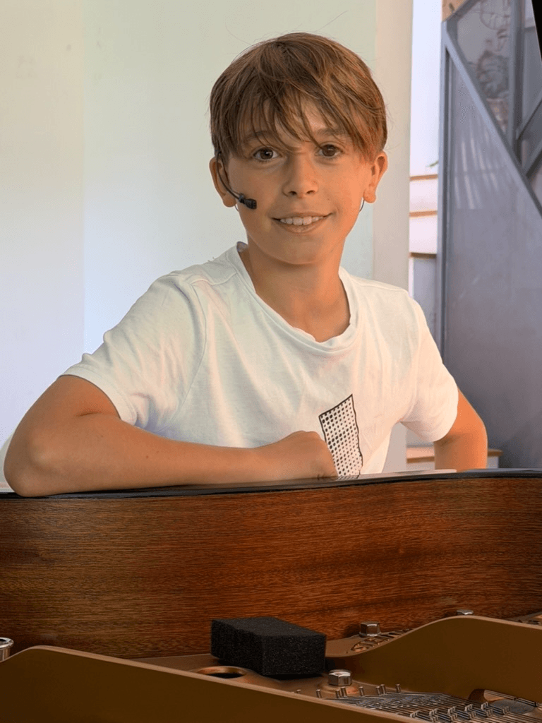 Lucas García Marín sonriendo al piano con un micrófono de diadema